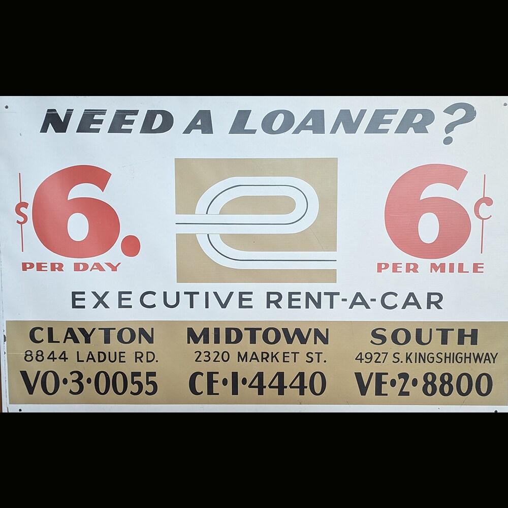  An Executive Rent-A-Car banner promoting loaner vehicles for $6 per day