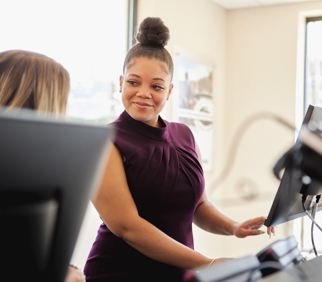 Man and woman talking on a sunny day at the rental car lot.