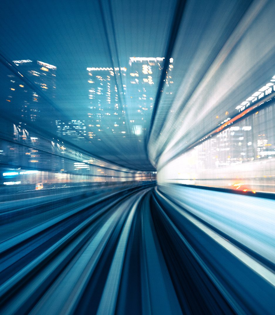 A night scene in a city showing motion under a blue tint