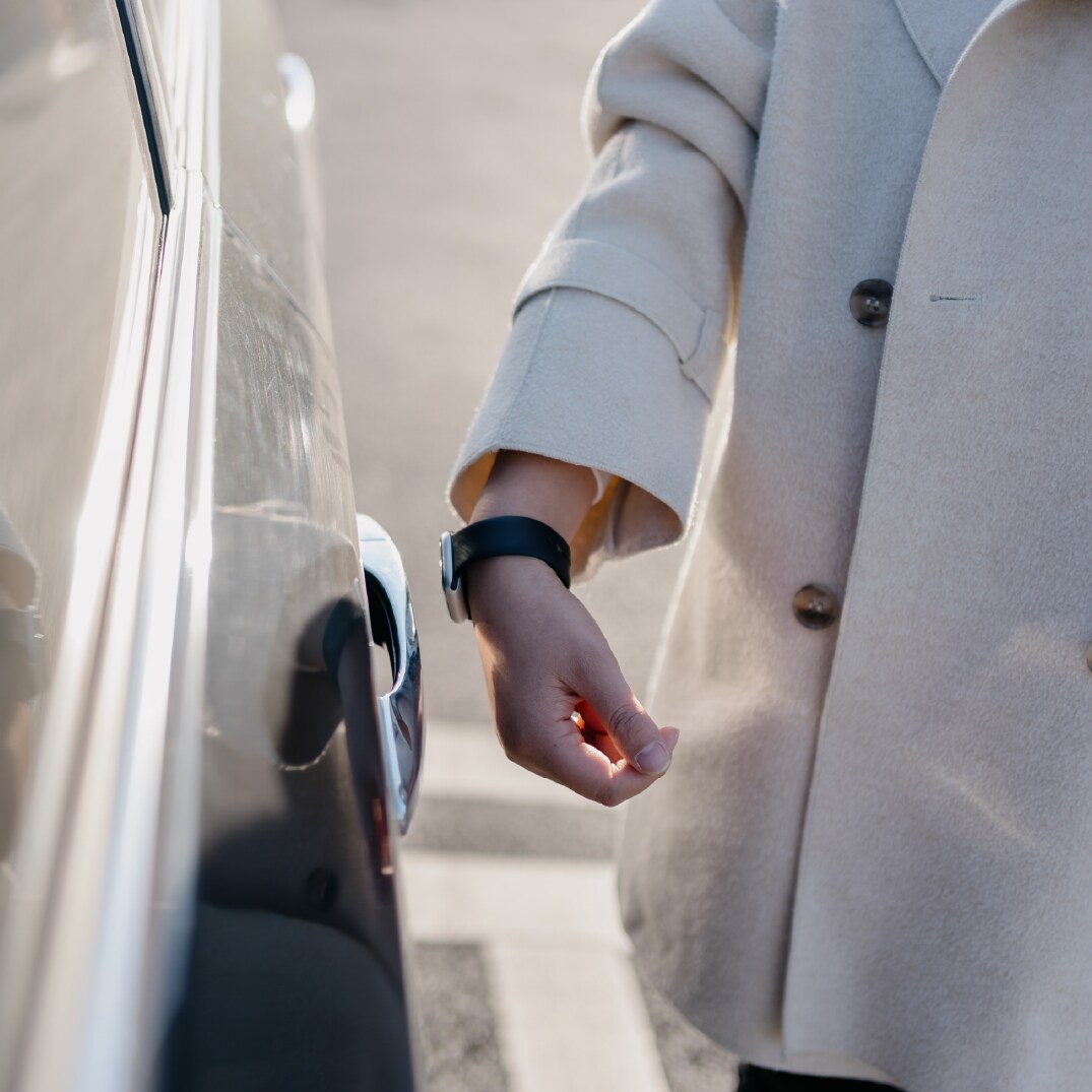 Woman uses her bracelet to open a car door
